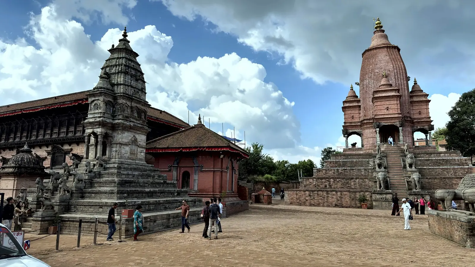 Stone shikhara temples on stepped plinths in Bhaktapur Durbar Square under a blue sky