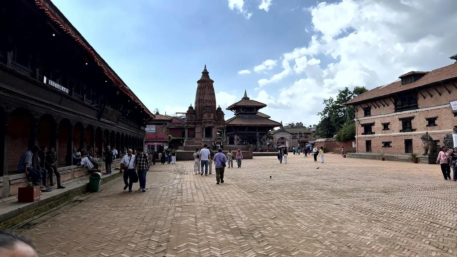 Wide view across the brick-paved Bhaktapur Durbar Square towards its temples